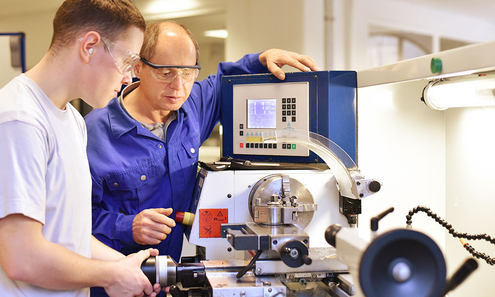 Student and teacher using machinery