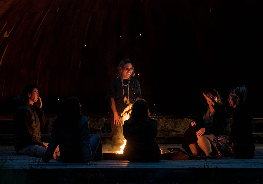 People gathered around a fire sharing stories