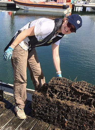 Female marine biology student inspecting shellfish