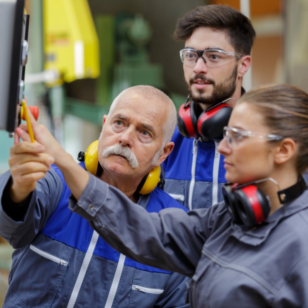 Apprentices learning how to use machinery with foreman