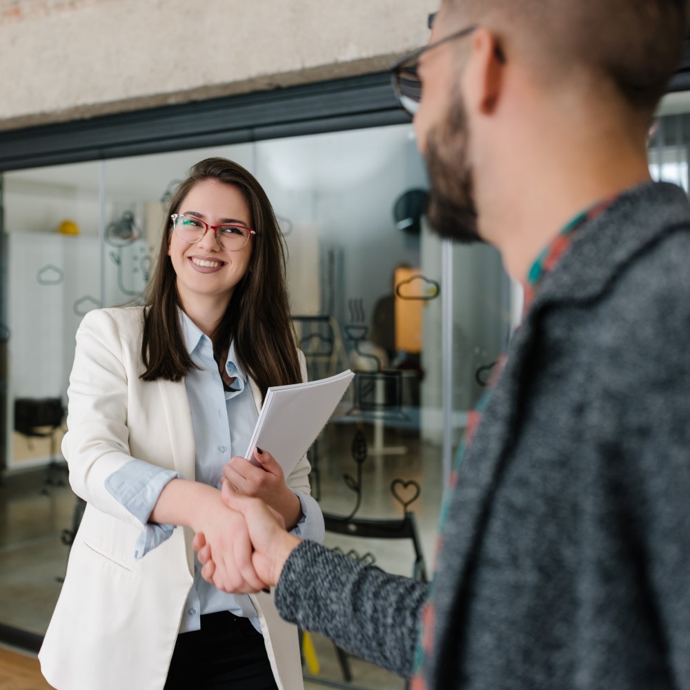 Business woman shaking hands with man