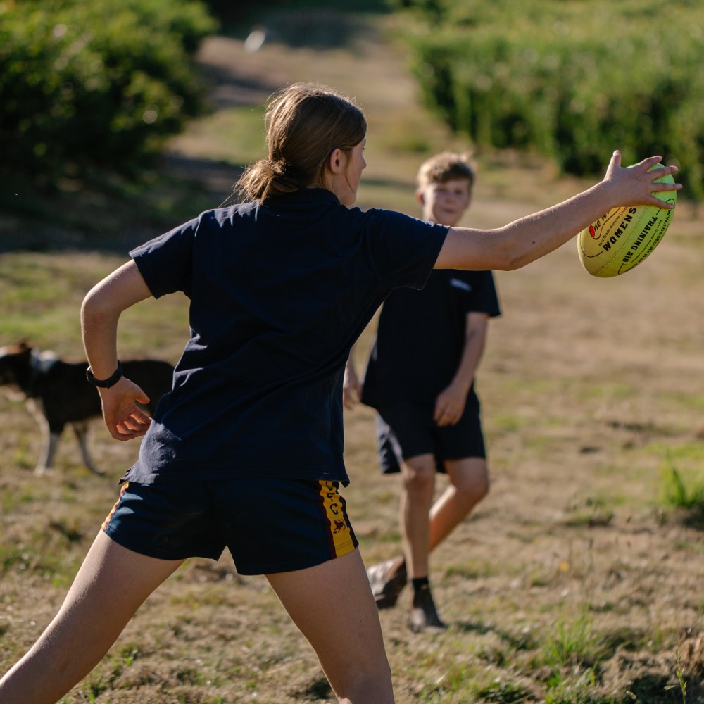 two young people kicking a football