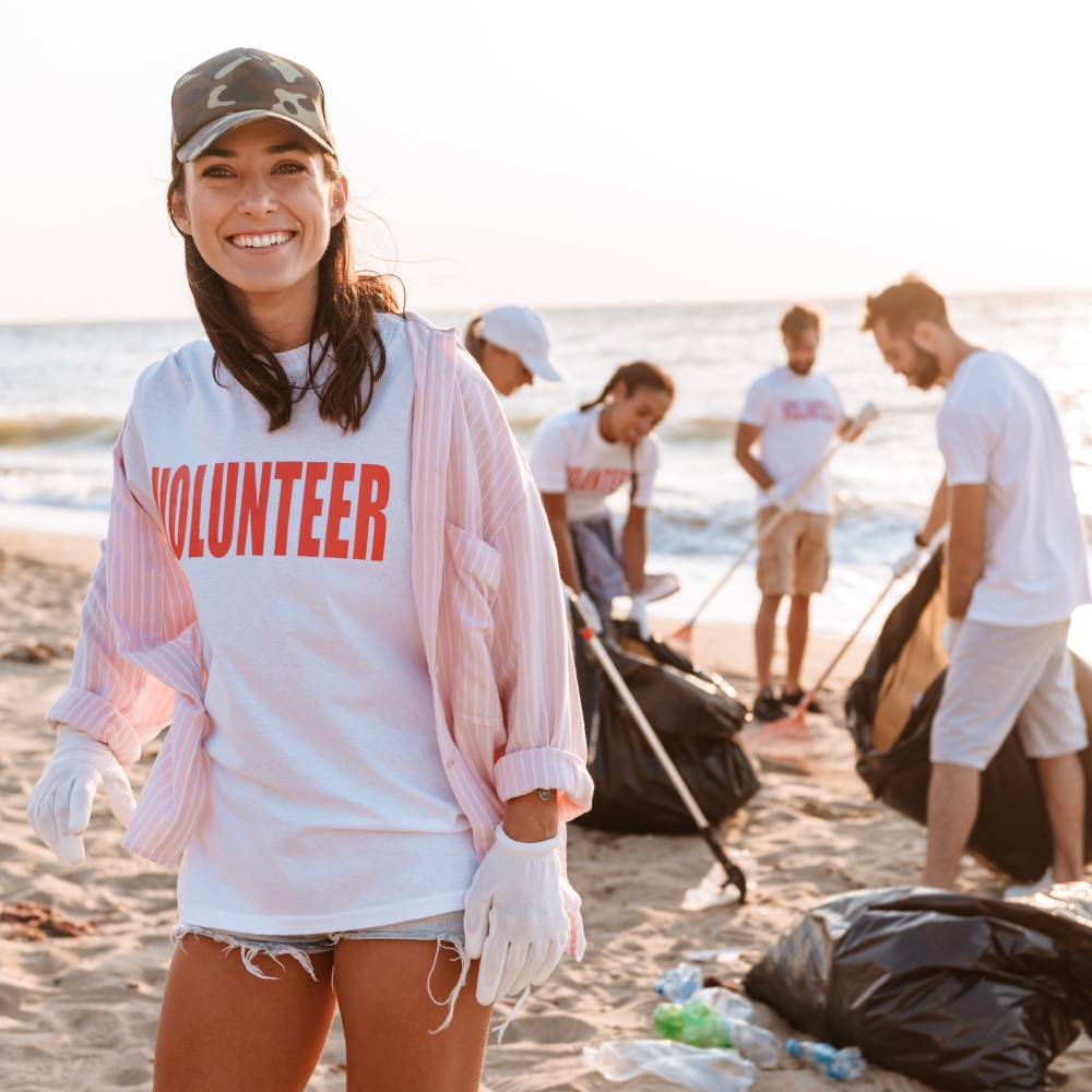 group of volunteers cleaning rubbish from a beach