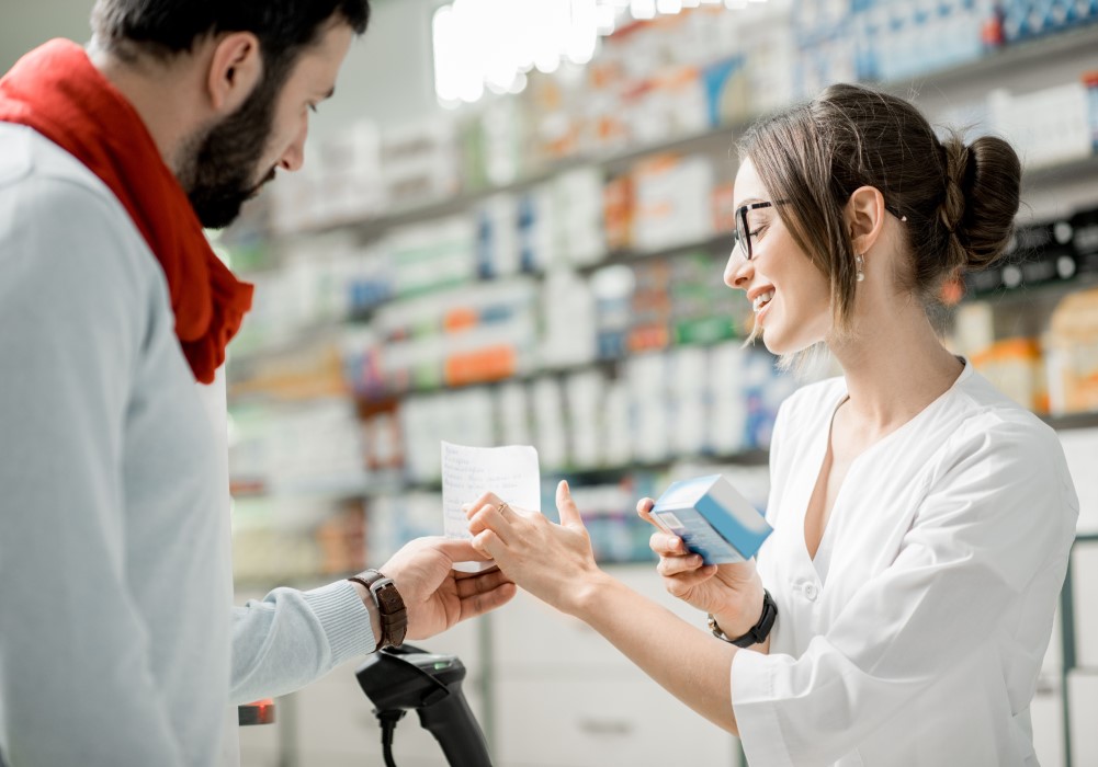 Young woman serving customer in pharmacy