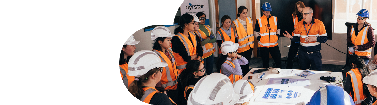 Group of students dressed in safety gear listening to industry expert