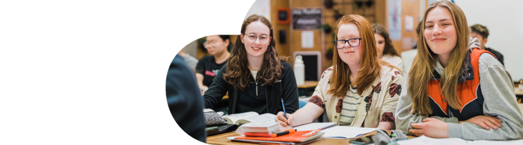 Group of female students sitting in a classroom smiling