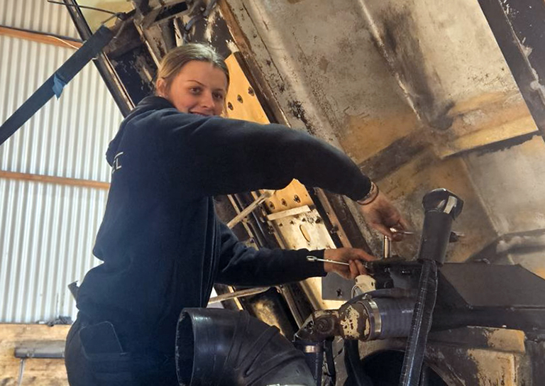 Young female mechanic working on a truck engine