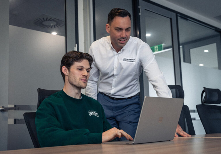 Two professional men working on a laptop together