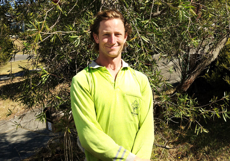 Young male smiling at camera with bright coloured top