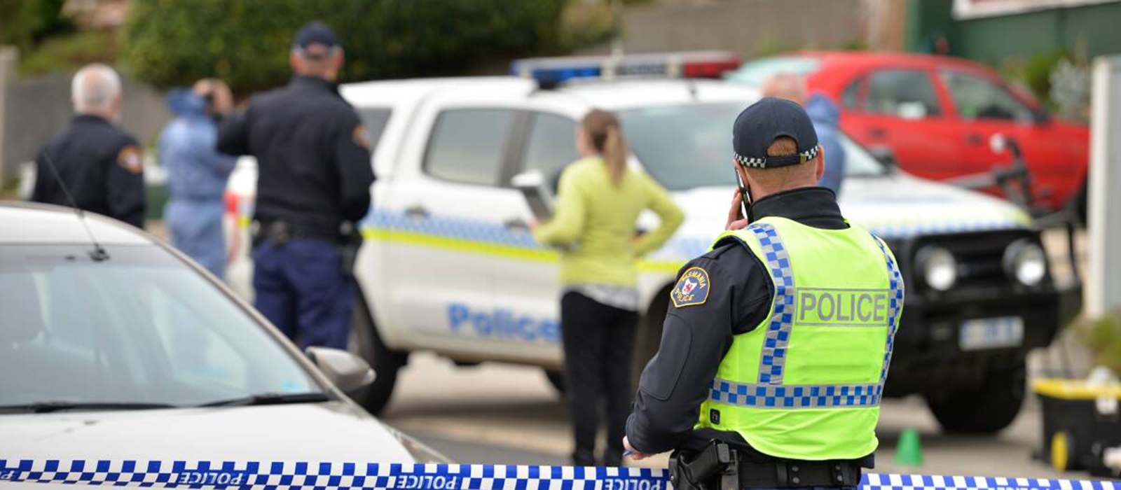 Male police officer observing restricted area of crime scene