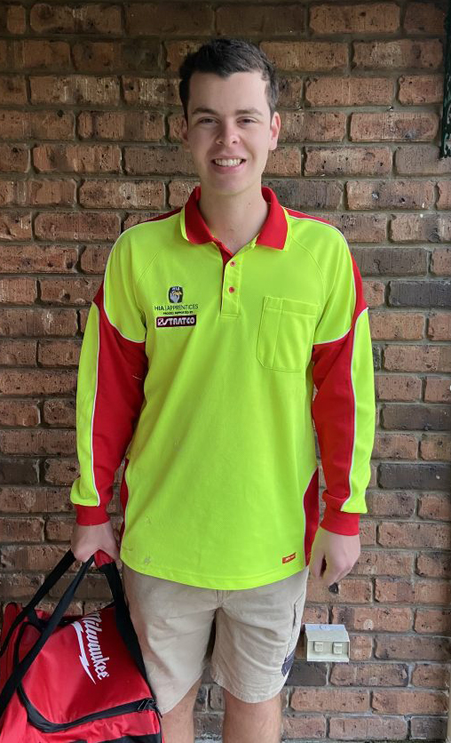 Young apprentice plumber smiling at camera going to work