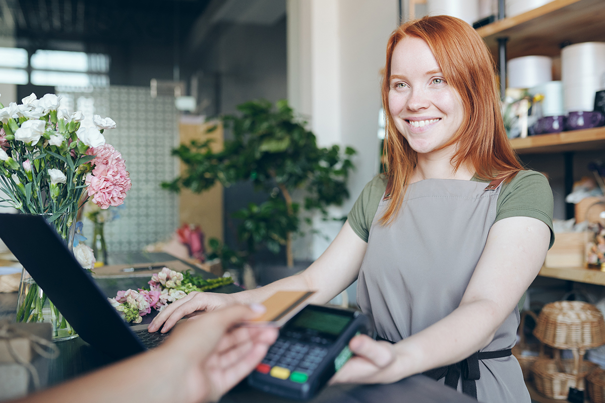 Young female retail worker serving customer