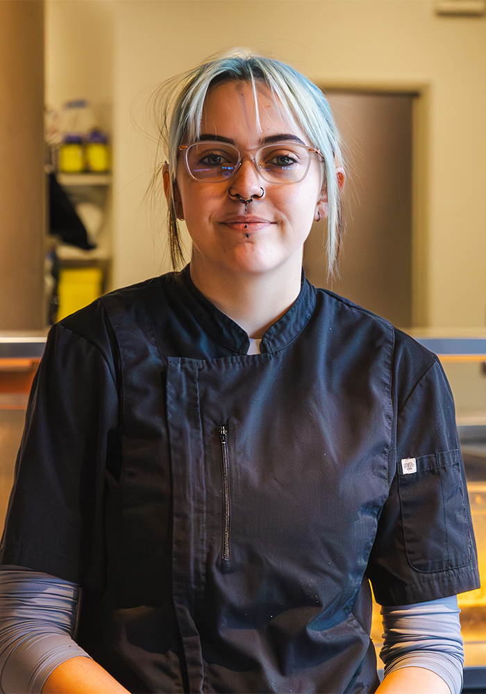 Young female chef with glasses smiling at the camara