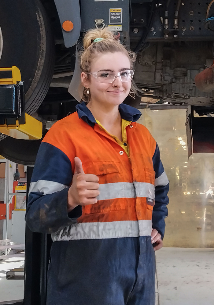 Young female mechanic giving the thumbs up