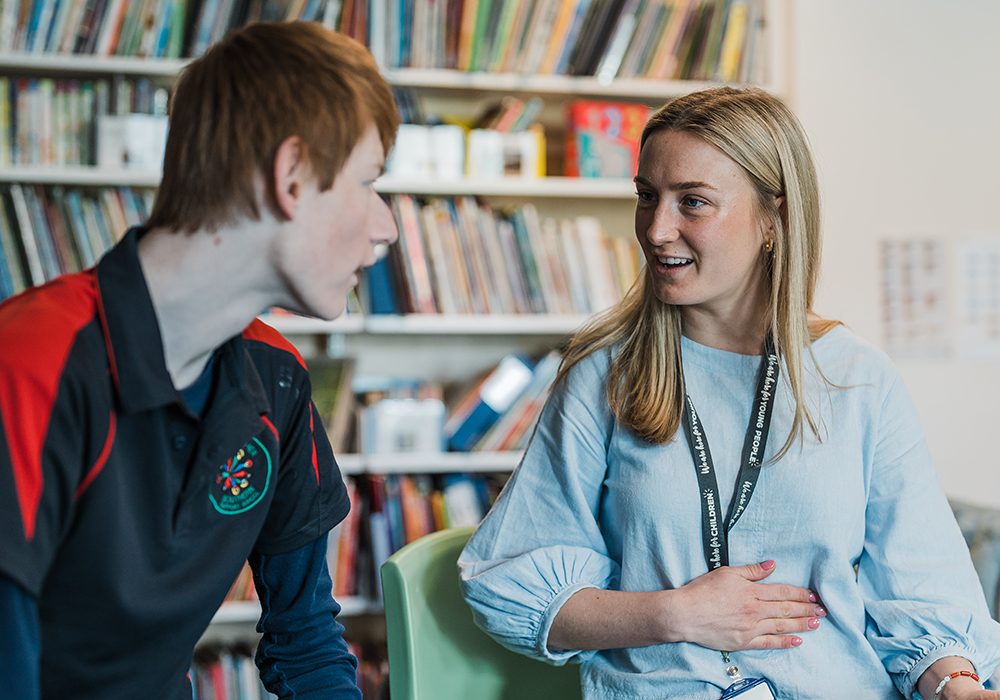 Female support teacher talking with a student with disability