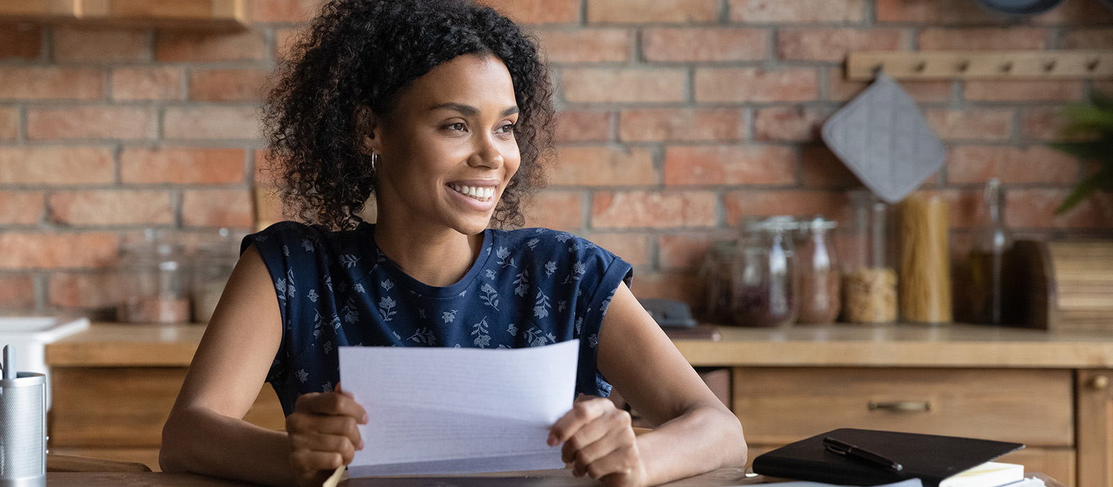  Happy dark skinned female holding piece of paper and smiling