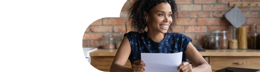 Young dark skinned woman smiling and holding a piece of paper